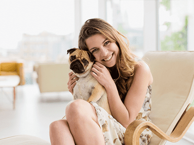Young woman with dog sitting in chair smiling